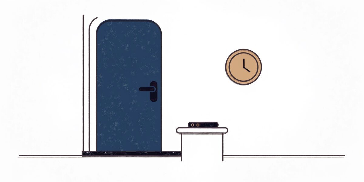 Porte d'appartement close vue du palier, avec un téléphone et une horloge murale à côté