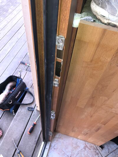 Porte en bois ouverte, sacoche à outils et tournevis posés au sol