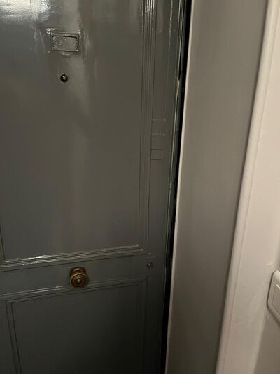 Porte peinte entrebâillée, bouton de tirage en laiton